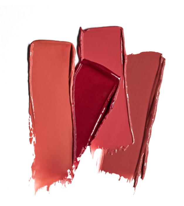 Swatches of creamy lip colors in warm, earthy tones and a bold red, arranged in artistic composition.